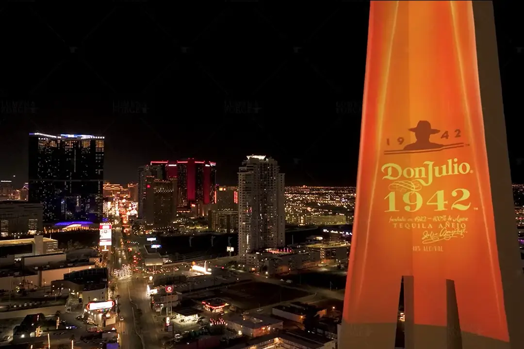 Don Julio 1942 label projection with the Las Vegas skyline behind the tower