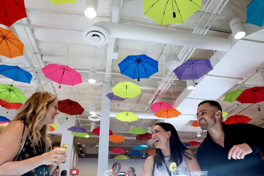 Guests under colorful umbrellas during the Planet 13 VIP opening event