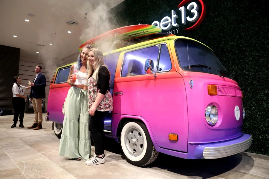 Guests posing with the smoke-emitting VW bus at the Planet 13 VIP event