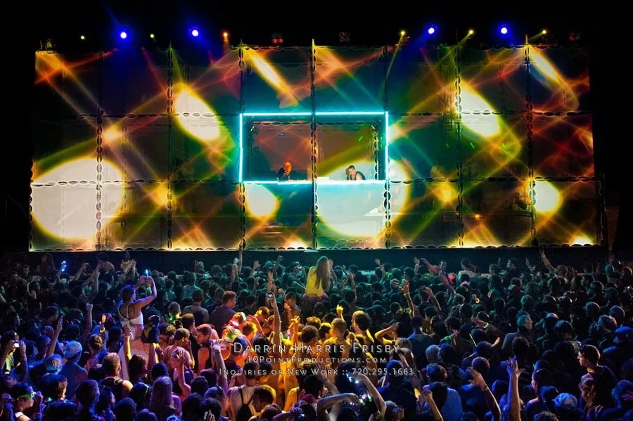 Wide crowd view of the Tower of Babel stage glowing with multicolor mapped visuals
