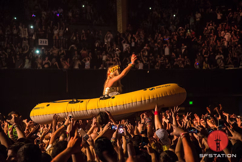Steve Aoki riding an inflatable raft over the audience during the Aokify America Tour