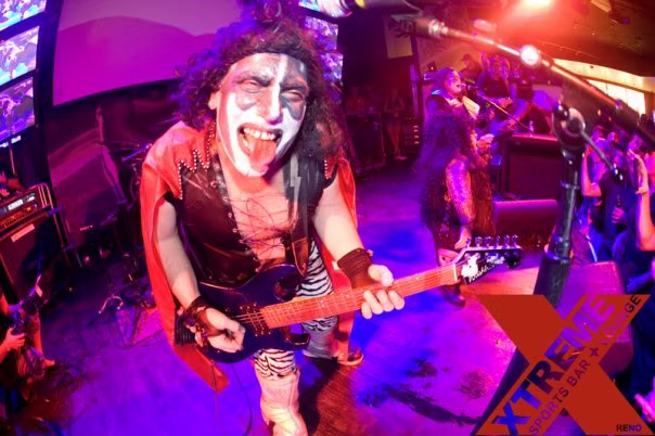 Guitarist performing under saturated stage lighting at XTREME