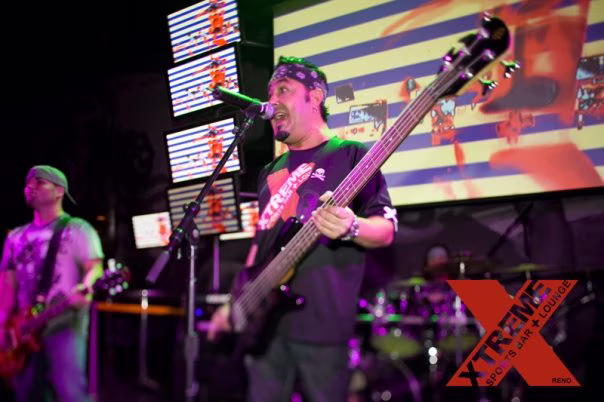 Live band performing at XTREME in front of the venue's giant projection screen